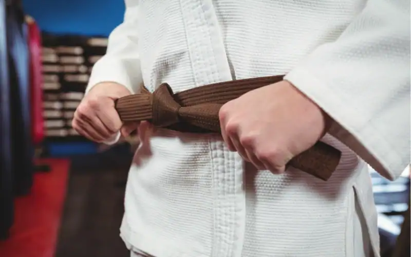 BJJ Gi belt tutorial showing proper technique to wrap and tie the belt securely for training.