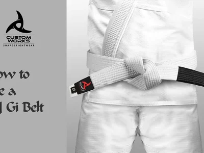 How to tie a BJJ Gi belt step-by-step, showing a student in a white Gi demonstrating proper wrapping and knotting techniques.